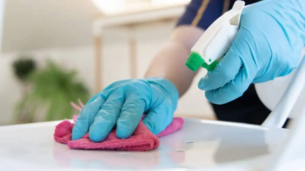 Residential cleaning team sanitizing a kitchen counter with professional maid service.