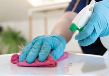 Residential cleaning team sanitizing a kitchen counter with professional maid service.